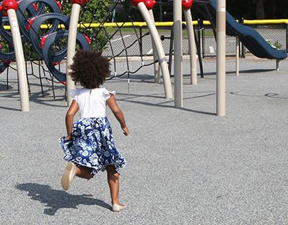 A young girl runs across a playground.