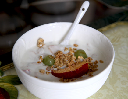 A bowl of yogurt with fruit and granola.