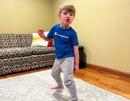 A boy standing in a frozen dance position.