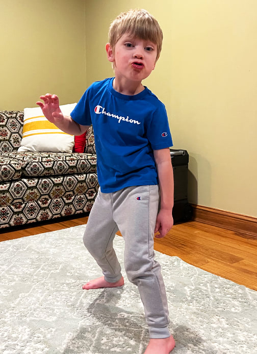 A boy standing in a frozen dance position.