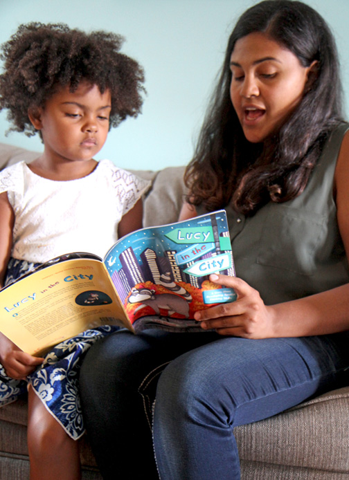 A mother and daughter read the book “Lucy in the City” by Julie Dillemuth.