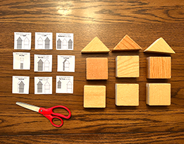 Square and triangular blocks, scissors, and “Block Party” activity cards laid out on a table.