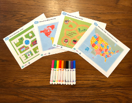 Four different map printouts, depicting a farm, a city, the United States, and the world, fanned out next to a pile of markers.