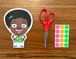 A printout of the Gracie cartoon character, scissors, and brightly colored dot stickers.