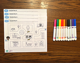 Printouts of a city maze activity next to a pile of markers.