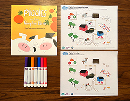 Mary Peterson and Jennifer Rofé’s book “Piggies in the Pumpkin Patch,” printouts of a farm scene, and markers laid out on a table.