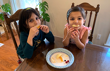 Two children eating fruit.