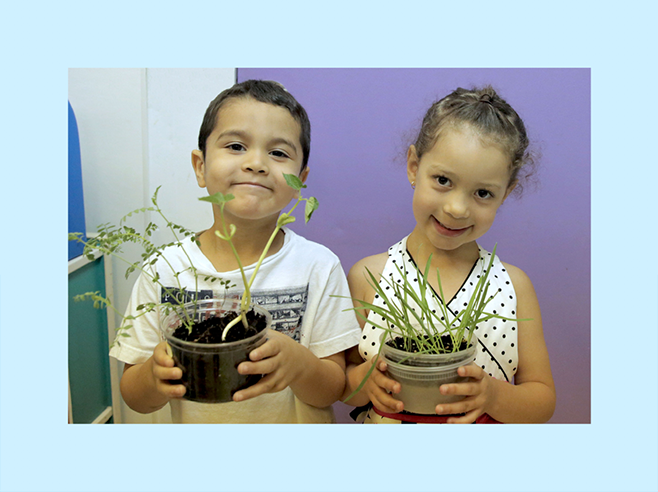 Dos estudiantes con sus plantas.