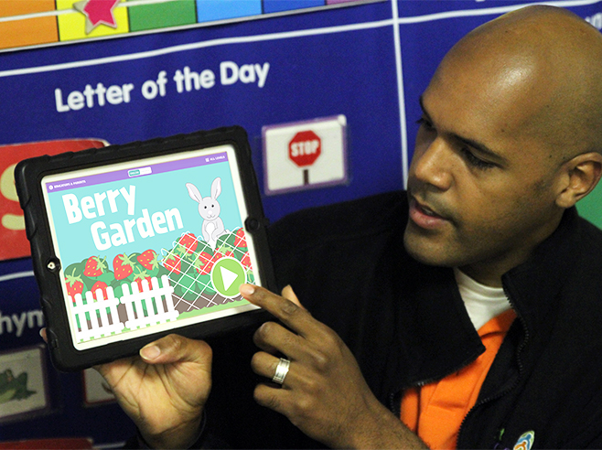 Teacher showing Berry Garden app on iPad.