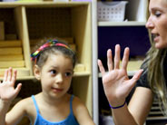Student and teacher holding up five fingers.