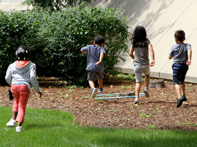 A group of students run to a hula hoop.