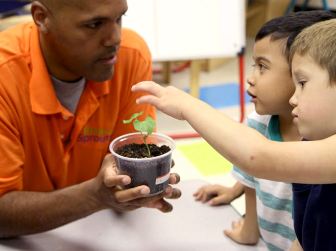 Teacher points to a part of the plant while student observes.