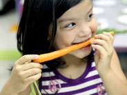 A student snacks on a carrot.