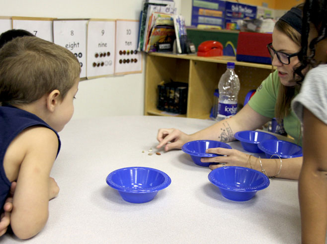 Students watch as teacher sorts seeds.