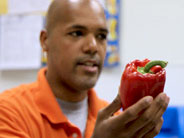 Teachers holds up a bell pepper.