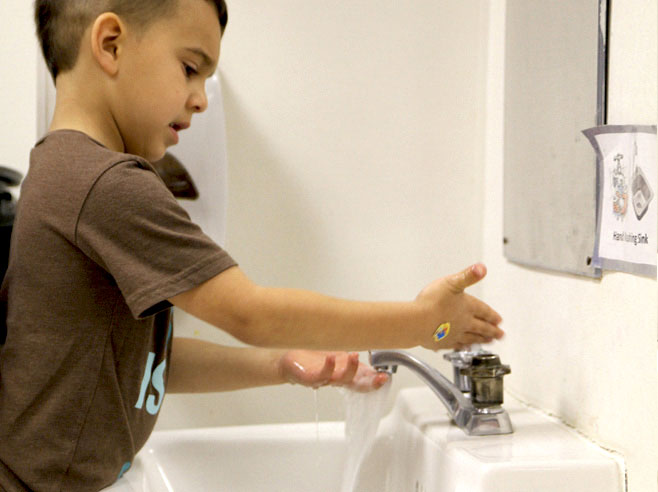 Student washes his hands.