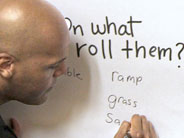 Close up of a teacher writing some different textured surfaces on a poster.
