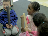 Students hold materials for making a giant marble run.