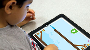 Student playing Coconut Canyon app on iPad.