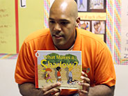 A teacher holds up the book, 'What Makes A Shadow?'.